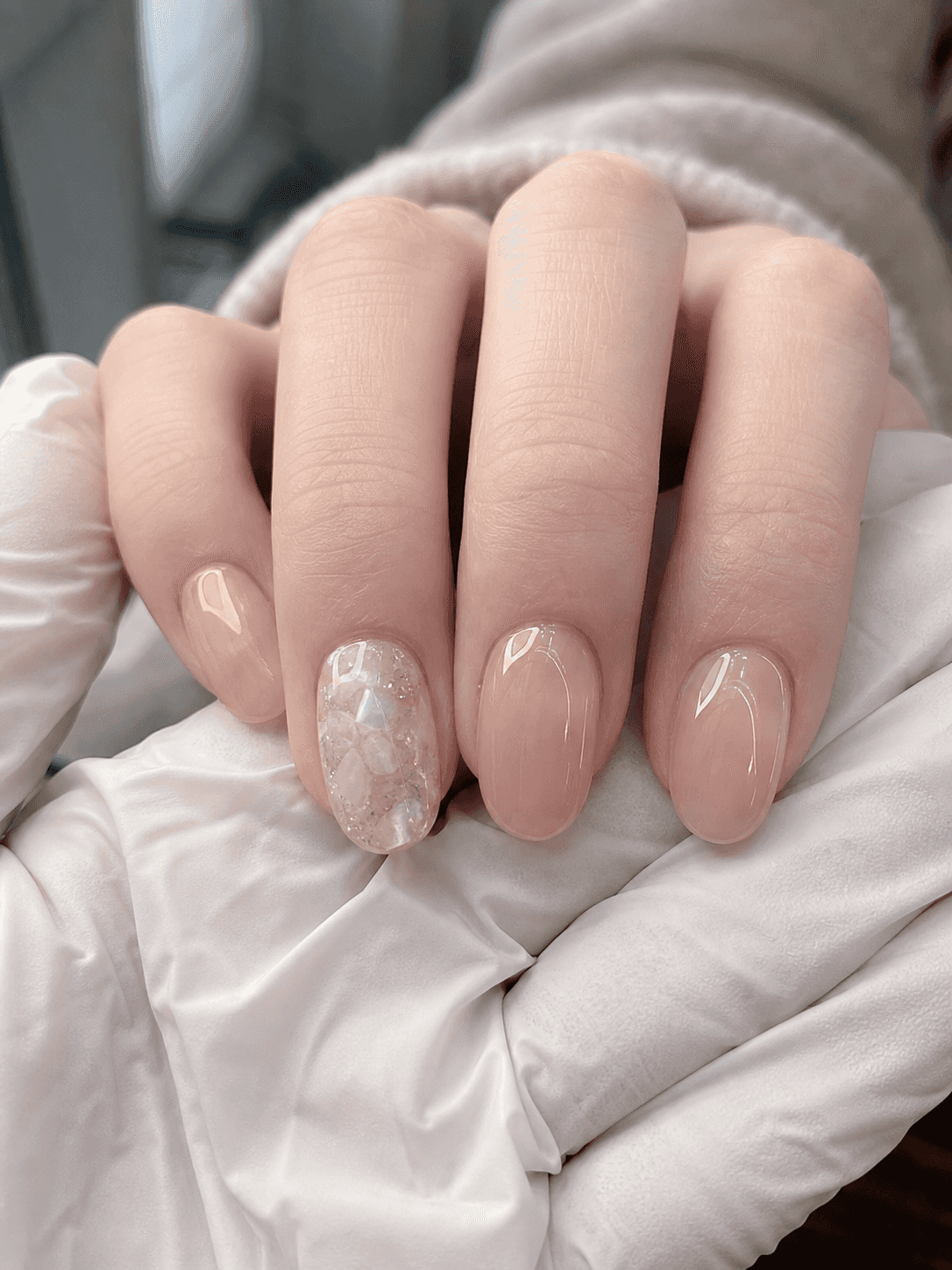 Glänzendes rundes Nageldesign in Nude und Weiß