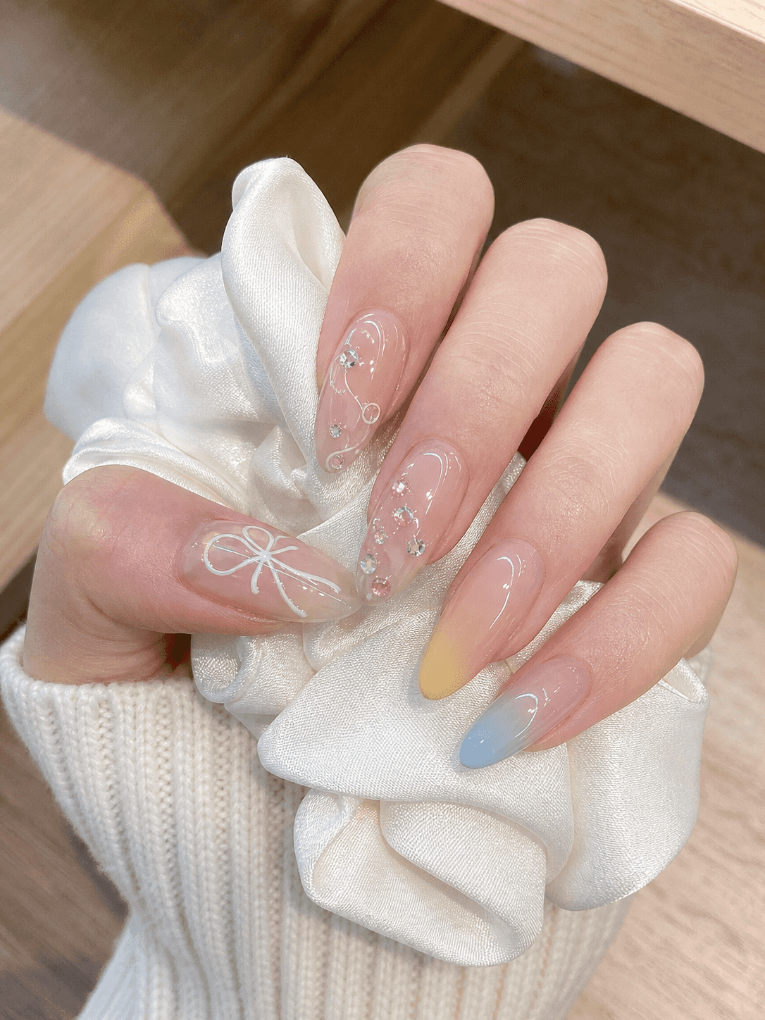 Glänzendes ovales Nageldesign in Nude und Weiß