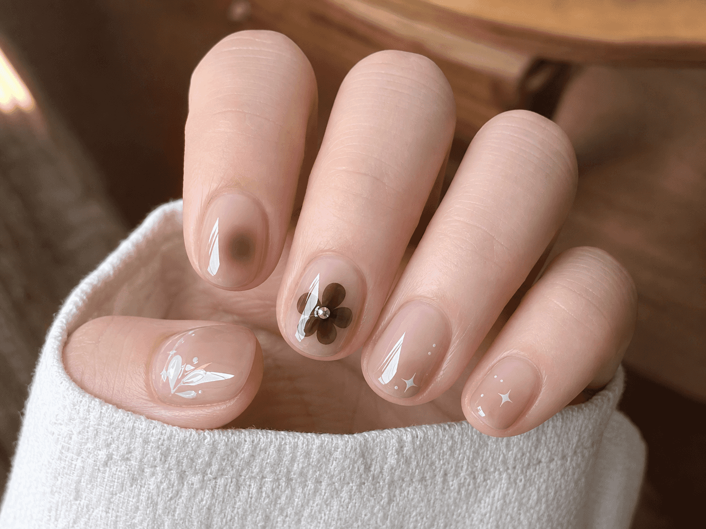 Glänzendes rundes Nageldesign in Nude und Weiß