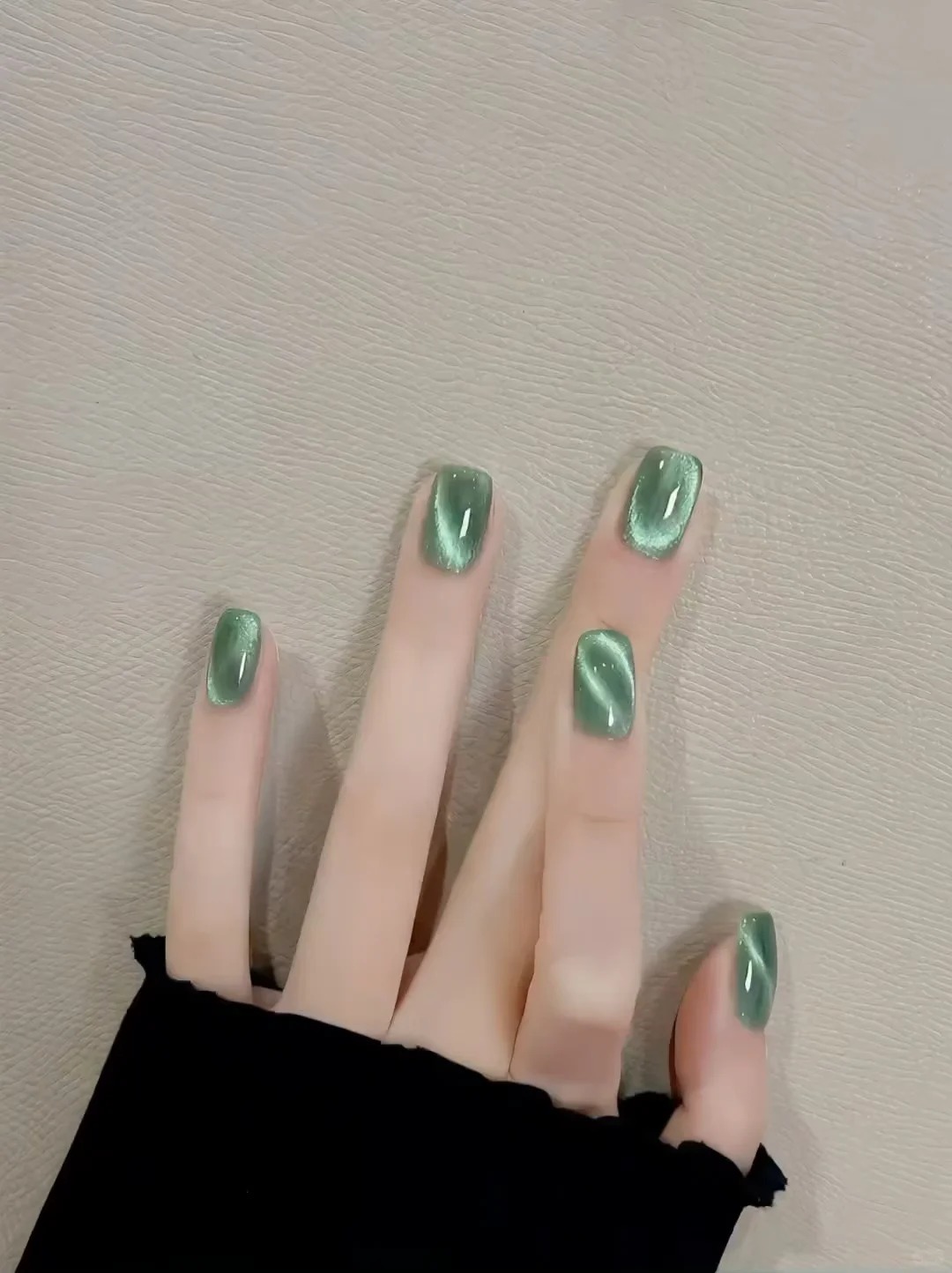 짧은 스퀘어 네일의 글로시 에메랄드 그린 캣아이 매니큐어
