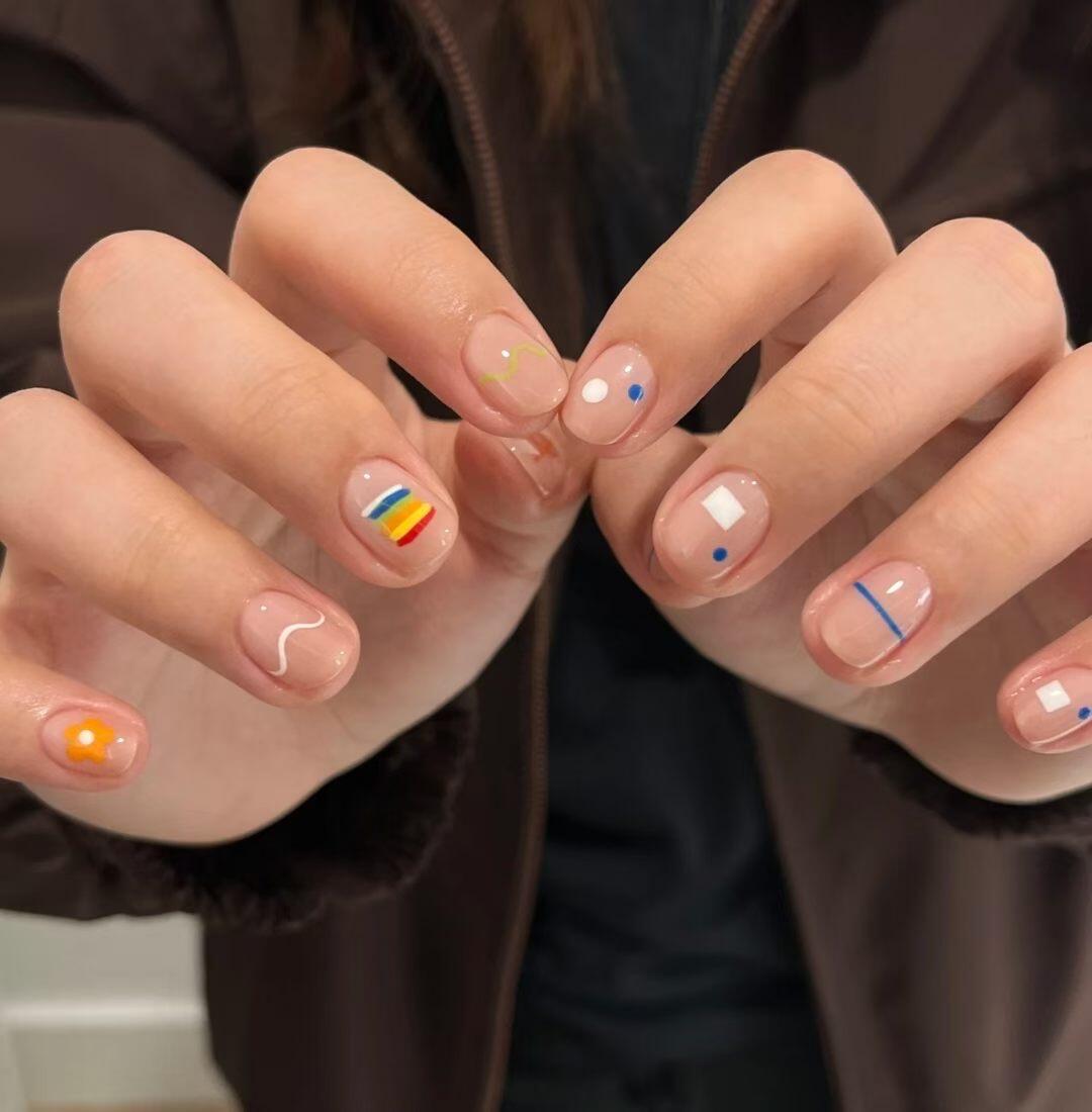 Bright summer nail designs on a white sandy beach background